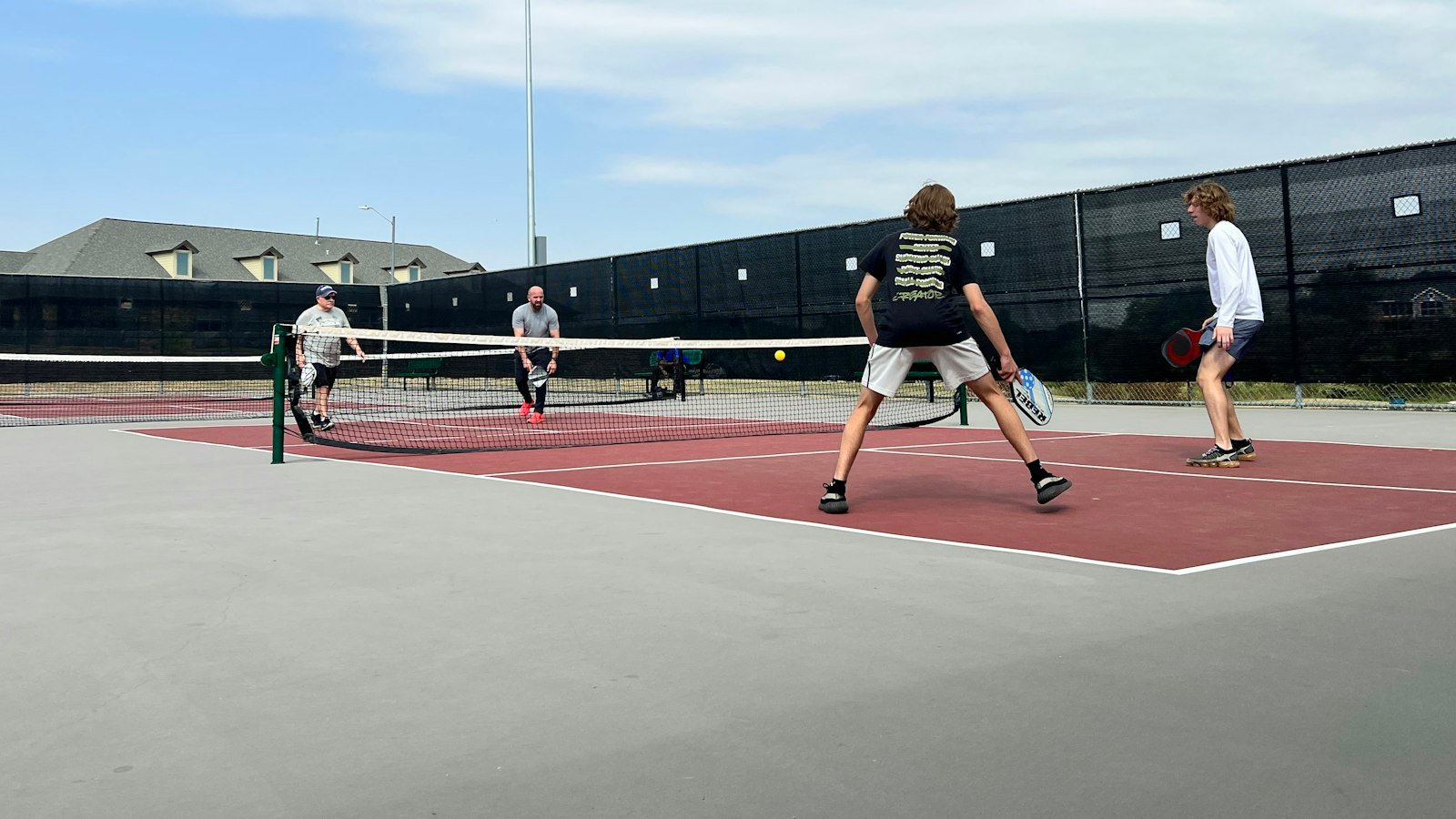 Group of adults playing pickleball on an outdoor court