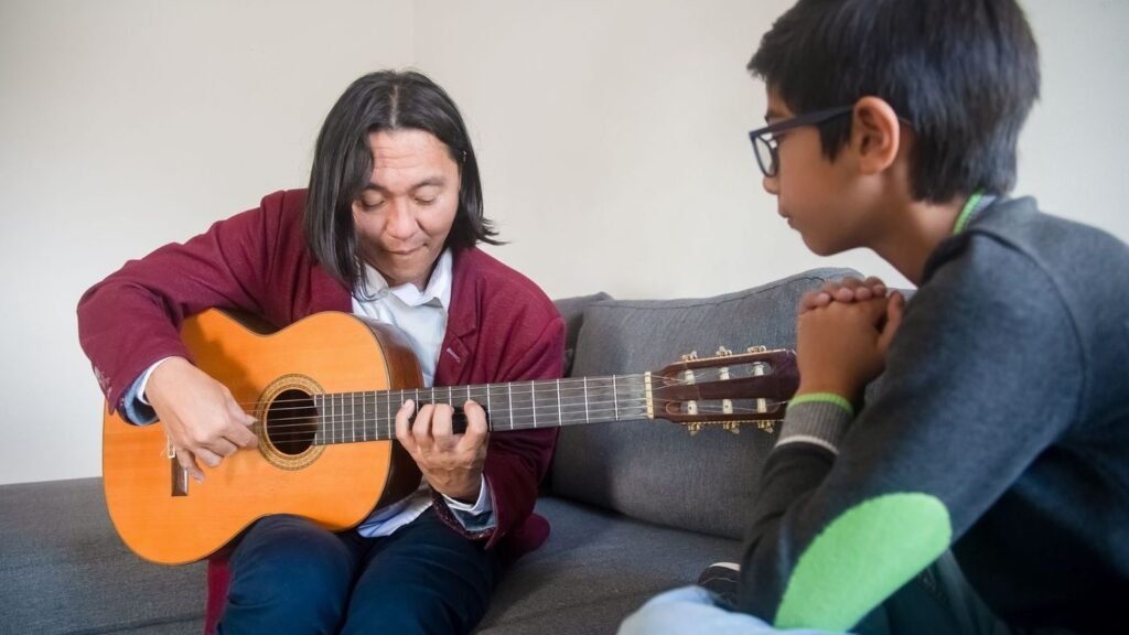 Guitar teacher showing a chord to a young student