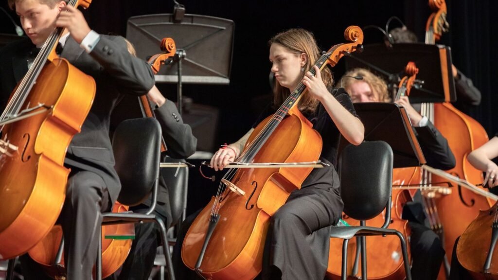 Young string players performing in a school orchestra