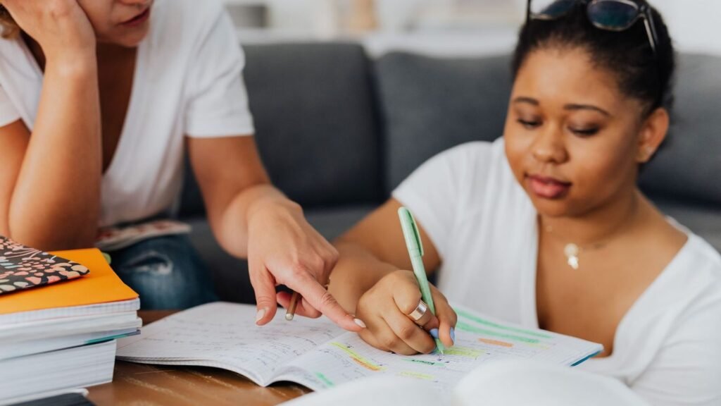 Tutor pointing to a student's workbook while explaining feedback