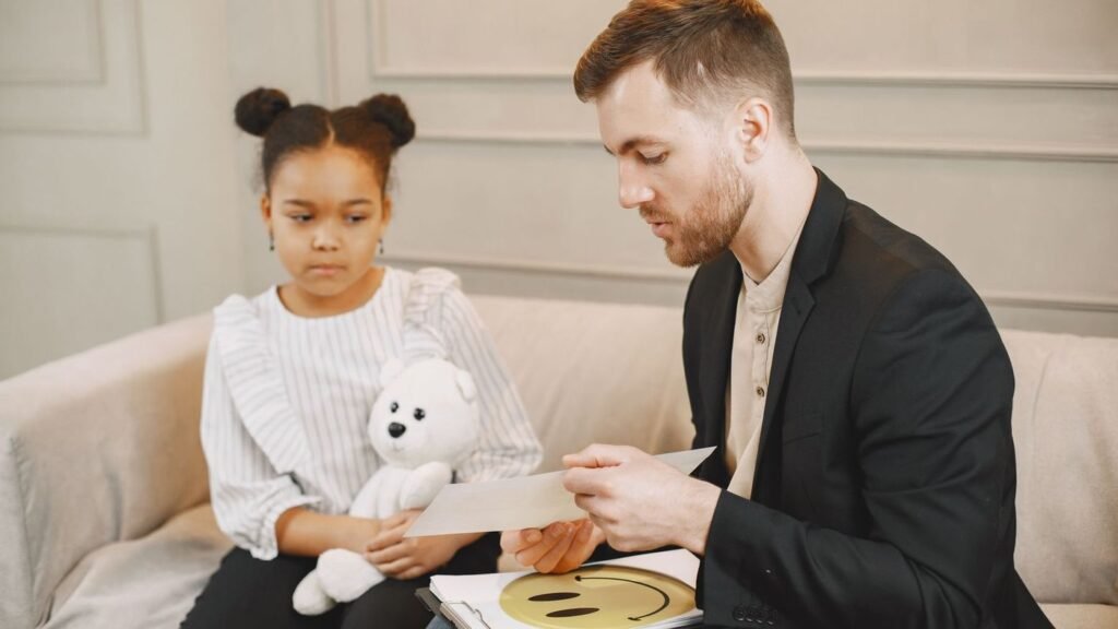Teacher sitting with a young student and going through her work