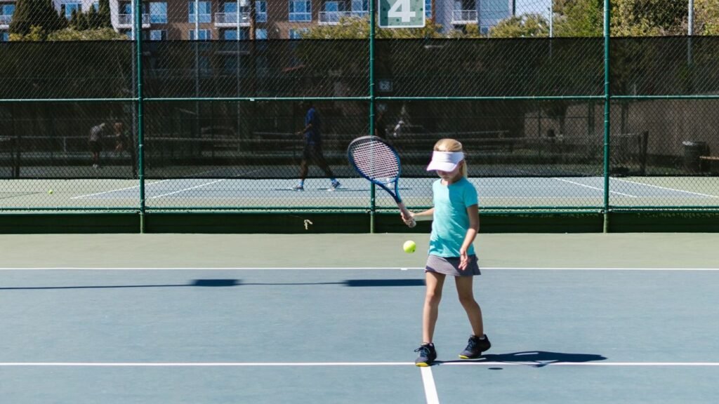 Junior player hitting a forehand on a hard court